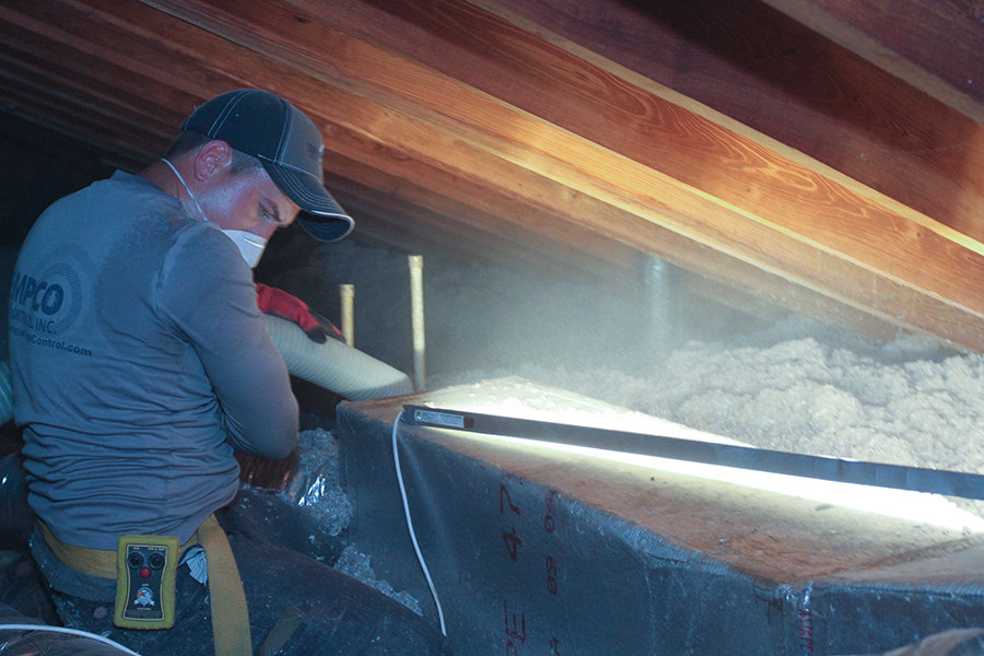 A Tempco Pest Control technician using the certified TAP insulation process for attic restoration in Naples, FL.